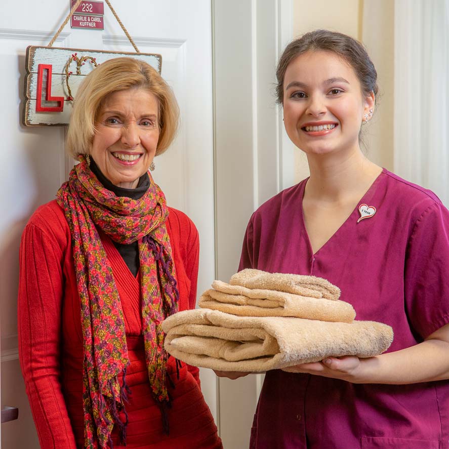 A team member delivering fresh linens to a resident at Chesterfield Heights
